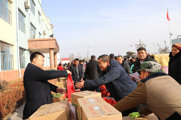 松兴屯党支部书记徐林收亲自为村民分发年货