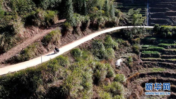 2月17日，在江西省万载县高村镇新竹村，罗长石骑行在山路上，他要去最偏远的村组，给孩子们送当天的线上教学课程（无人机照片）。 新华社记者 彭昭之 摄