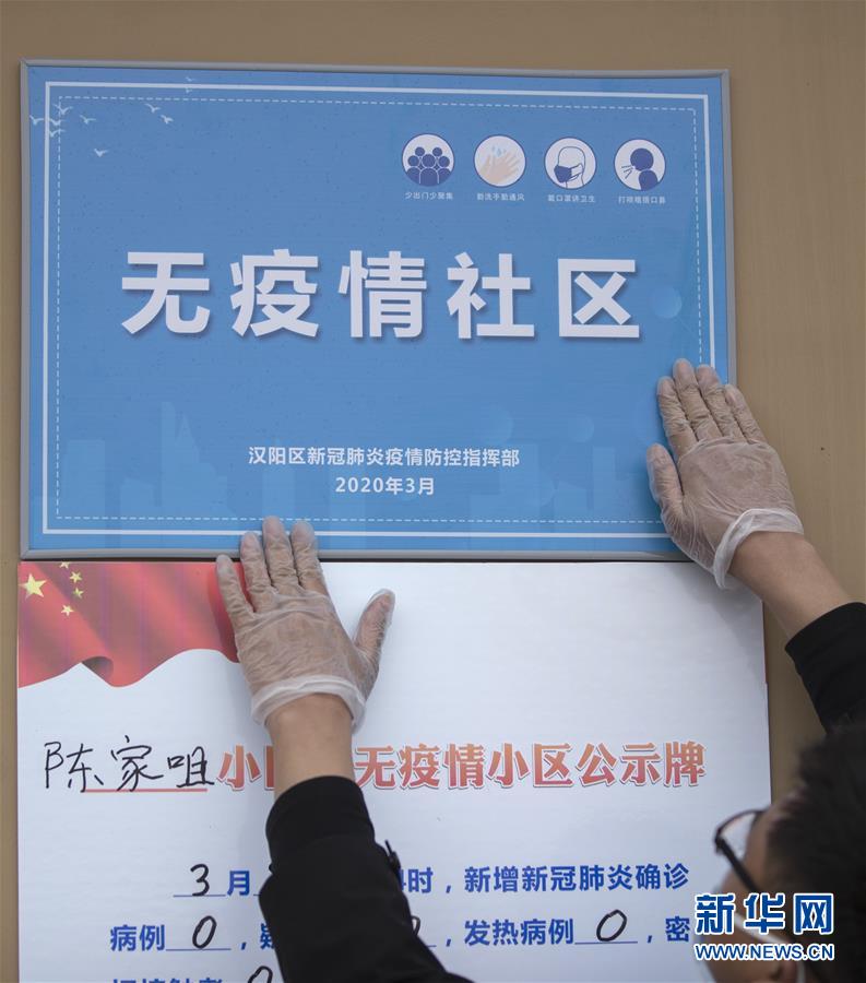 3月9日，汉阳区陈家咀社区工作人员将“无疫情社区”的牌子贴到墙上。