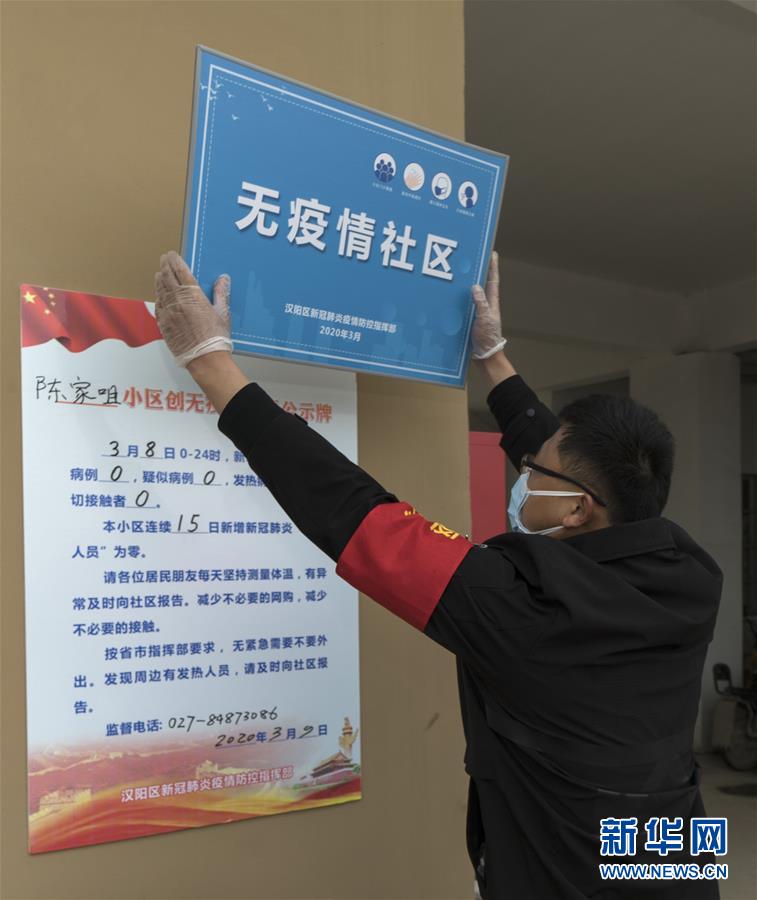 3月9日，汉阳区陈家咀社区工作人员将“无疫情社区”的牌子贴到墙上。