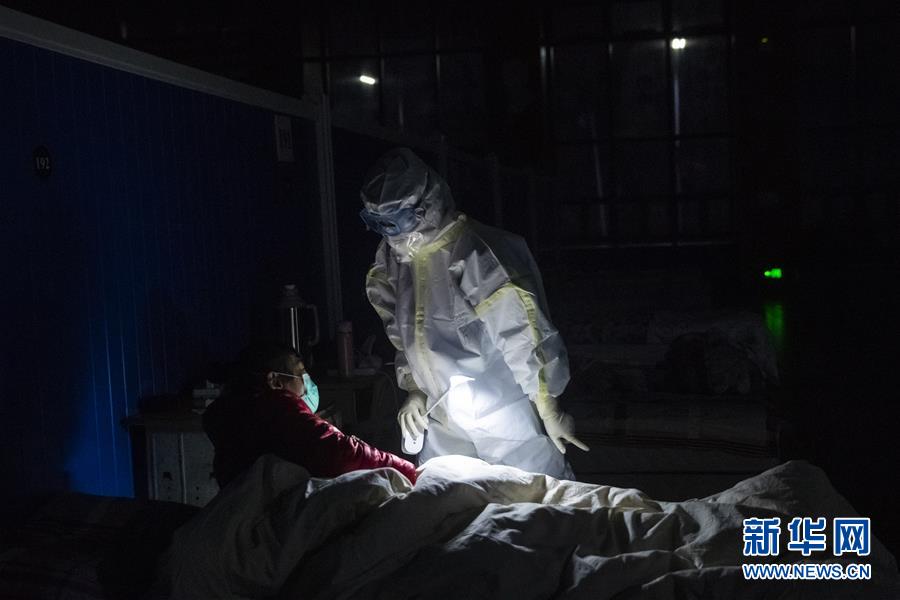 3月9日晚，在位于武汉市洪山体育馆的武昌方舱医院，江西支援湖北医疗队队员胡佩在熄灯后巡视。