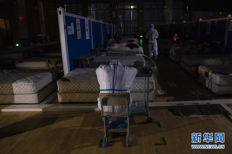 3月9日晚，在位于武汉市洪山体育馆的武昌方舱医院，一名医务人员趴在小架子上休息。