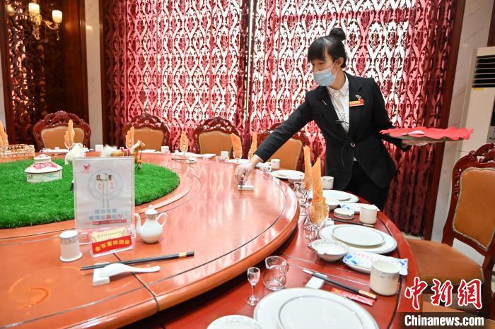 资料图:2021年1月13日,呼和浩特某酒店工作人员在餐桌上摆放公筷。刘文华 摄 点击进入下一页