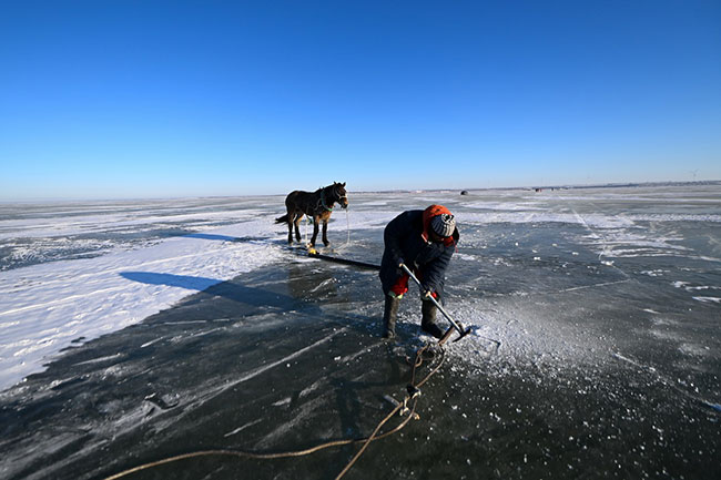 12月26日，渔民在查干湖冰面上准备安装捕鱼用的绞盘。