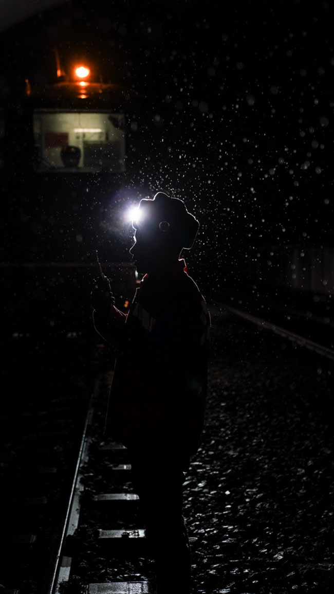 鹰潭工务机械段工作人员在夜间指挥机车作业（1月27日摄）。