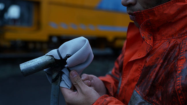 工作完成后，鹰潭工务机械段工作人员利用擦机布安装“话筒”隔音棉（1月27日摄）。