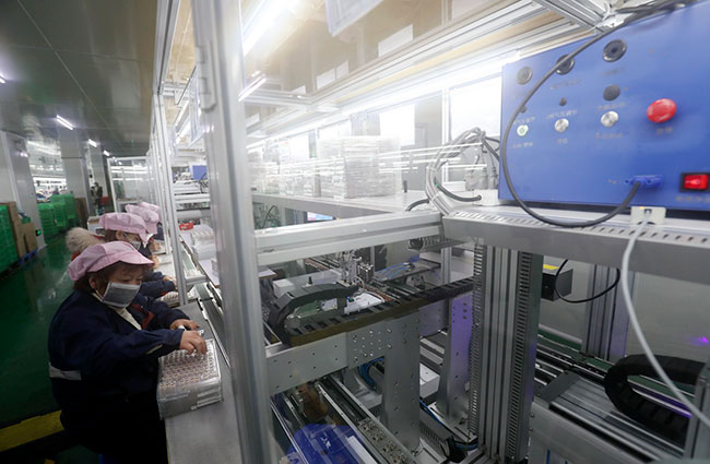 2月7日，湖南省资兴市经济开发区一家耳机生产企业的工人在车间忙碌。新华社发（李科摄）