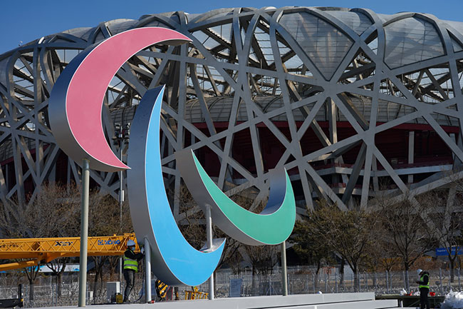 2月24日，工人在北京赛区国家体育场附近安装残奥会标志。新华社记者 陈钟昊 摄
