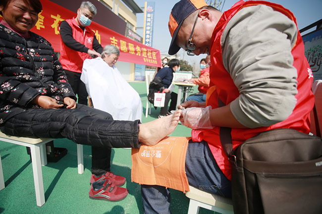 3月3日，在江苏省扬州市邗江区竹西街道安平社区，志愿者为居民修脚。新华社发（孟德龙摄）