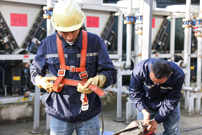 3月15日，“蜘蛛人”在系安全带，准备进行清洗作业。新华社记者 欧东衢 摄