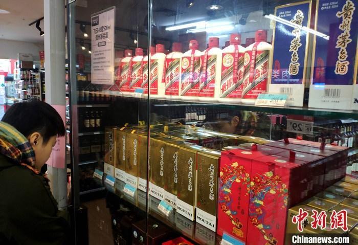资料图：市民在福建福州的一超市贵州茅台酒专柜了解信息。 <a target=