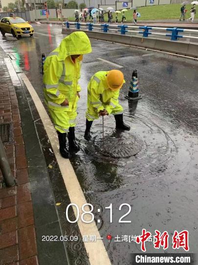 图为工作人员正在消除道路积水点。　重庆市住房和城乡建设委员会供图