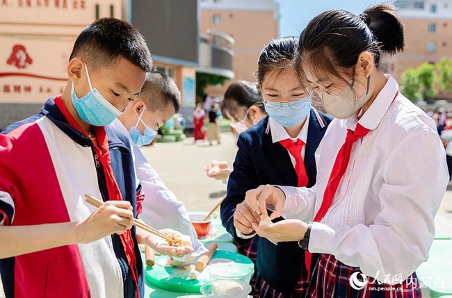5月30日，内蒙古呼和浩特市玉泉区恒昌店巷小学学生参加包饺子比赛。丁根厚摄