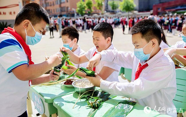 5月30日，内蒙古呼和浩特市玉泉区恒昌店巷小学学生参加包粽子比赛。丁根厚摄