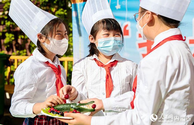 5月30日，内蒙古呼和浩特市玉泉区恒昌店巷小学学生相互交流制作果盘的技艺。丁根厚摄