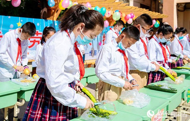 5月30日，内蒙古呼和浩特市玉泉区恒昌店巷小学学生参加黄瓜、土豆削皮比赛。丁根厚摄