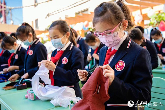 5月30日，内蒙古呼和浩特市玉泉区恒昌店巷小学学生参加缝纽扣比赛。丁根厚摄