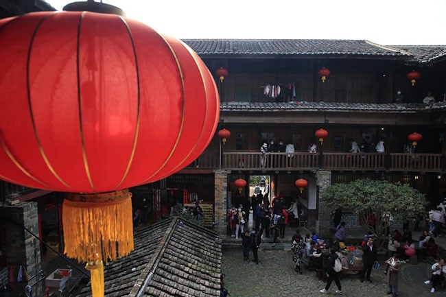 1月25日，游客在福建省龙岩市永定区土楼景区游玩。新华社发（周杨东 摄）