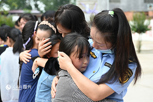 5月30日，河南省郏县妇联在安良镇西安良小学举行迎“六一”“佑未来 护成长”爱心妈妈结对帮扶活动。来自郏县纪委监委、县交通局、县农业农村局、县审计局、县医院的37名“爱心妈妈”志愿者与37名留守儿童“一对一”结成帮扶对子。“爱心妈妈”与孩子们谈心聊天，开心互动，捐赠书包、图书等礼物，一起欢庆六一儿童节。人民网记者 王玉兴摄 