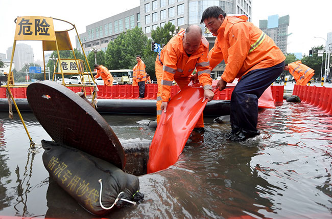 7月31日，在河北省石家庄市中山西路一积水路段，工作人员进行紧急排水。新华社发（张晓峰摄）