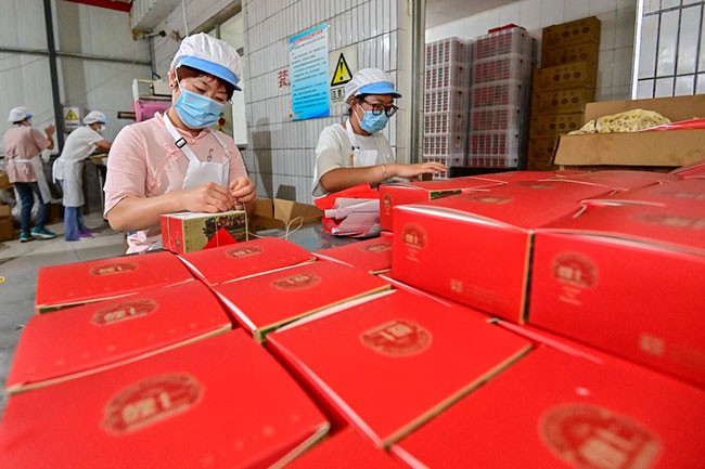 9月13日，在山东省青州市经济开发区一家月饼生产企业，工人在包装手工月饼。新华社发（王继林摄）