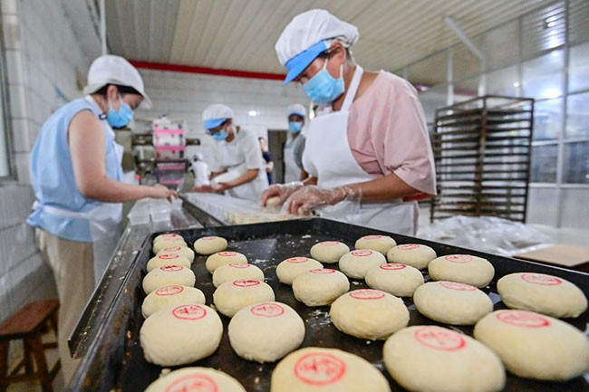 9月13日，在山东省青州市经济开发区一家月饼生产企业，工人在码放手工月饼。新华社发（王继林摄）