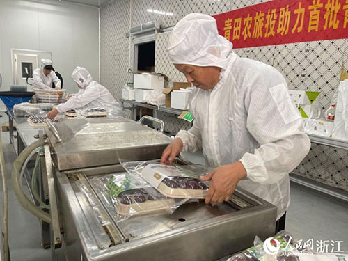 在全冷链杨梅车间里，工作人员正在对出口杨梅进行真空锁鲜包装。人民网记者 王丽玮摄