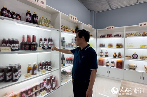 周增群介绍团队研发的各类杨梅深加工产品。人民网记者 叶宾得摄