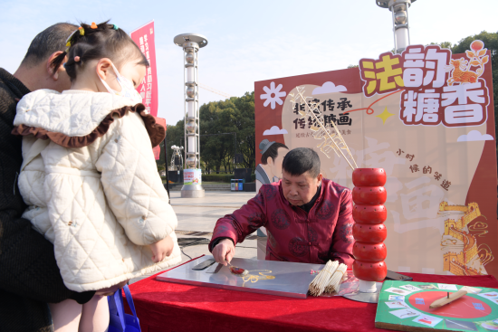 非遗普法糖画摊位匠人帮群众画糖画