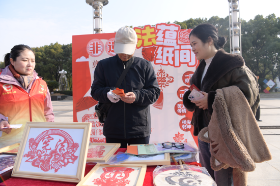 非遗普法剪纸摊位匠人帮群众剪纸